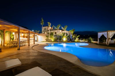 Experience luxury in a Mediterranean villa poolside at night, perfect for relaxation.